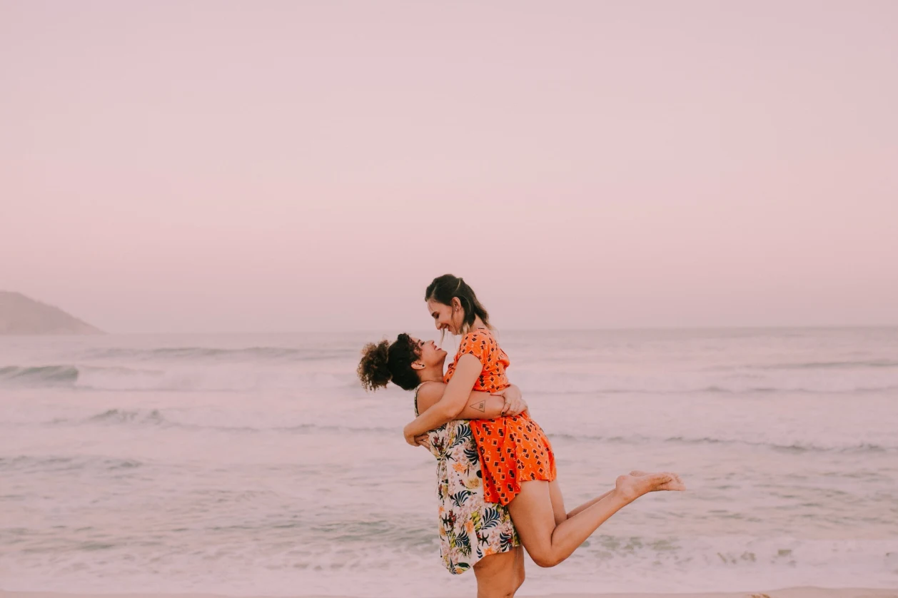 two women hugging on beach